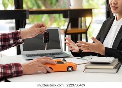 Dealer Handing Keys To New Owners. Car Sales Business. Buying Contracts. Customer And Sales Team Cooperation Concept After Agreement Successful Car Loan Contracts