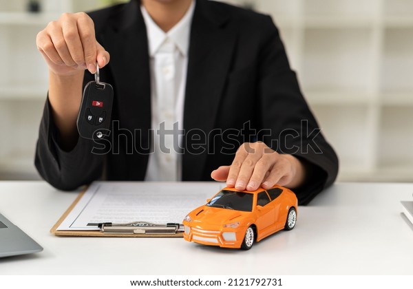 Dealer handing keys to new\
owners. Car sales business. Buying contracts. Customer and sales\
team cooperation concept after agreement Successful car loan\
contracts