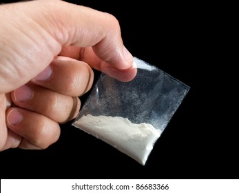 Dealer Is Holding Drug Bag In His Hand On A Black Background.