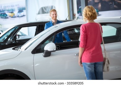 
Dealer Showing A New Car Model To The Potential Customer