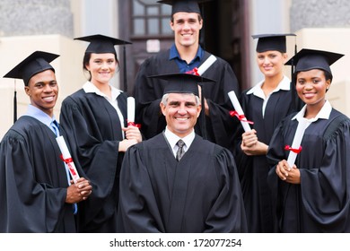 Dean Standing With Group Of Happy Graduates Outside University