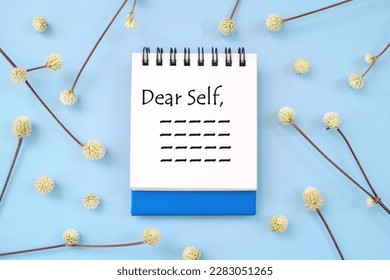Dear self, personal reflection and advice to self concept. Flat lay journal diary in blue background.