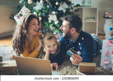 Dear, Tell Me Your Wishes. Family At Home Using Laptop And Credit Card.