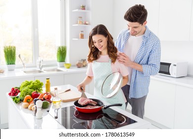 Dear When Meal Ready. Dream Harmony Two People Couple Girl Frying Pan Raw Fresh Meat Hold Spatula Man Touch Her Shoulders Enjoy Cooking Hobby Weekend In Kitchen House Indoors