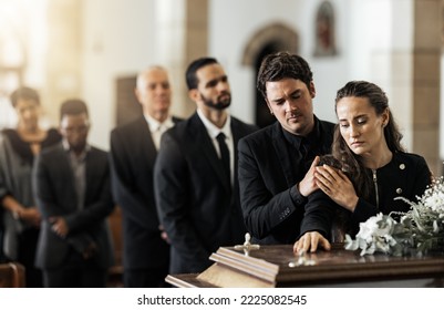 Muerte, funeral y familia tocando el ataúd en una iglesia, triste e infeliz mientras se reunían para decir adiós. El equipo de servicio de la iglesia y el hombre y la mujer tristes parecen molestos mientras saludan, despiden y destrozan