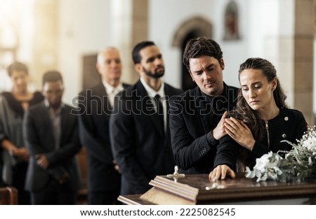 Death, funeral and family touching coffin in a church, sad and unhappy while gathering to say farewell. Church service casket and sad man and woman looking upset while greeting, goodbye and rip