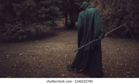 Death, Grim Reaper, With His Scythe Lurking In The Woods In A Haunted Forest