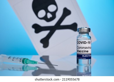 Death paper page behind covid vaccine and syringe. Printed skull symbol for vaccination promotion. Coronavirus vaccine saves lives. Dangerous effect of covid-19 breakdown. Antivirus vaccine for life.