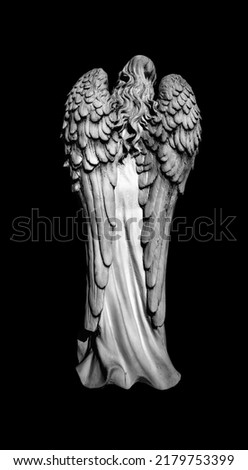 Death. Rear view of angel as symbol of pain, fear and end of life. Ancient stone statue. Black and white image.