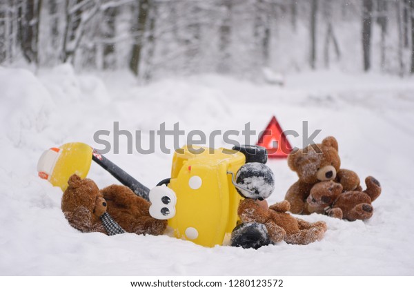 Death road accident in winter. Staging\
of an accident with teddy bears and a child\'s car. A photo with a\
strong emotional message. Dangerous\
driving.