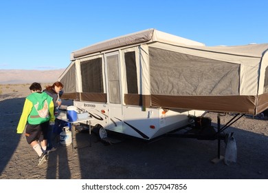 Death Valley, California, March 16, 2021: A Family Camping In Death Valley With A Tent Trailer And Cooking Dinner