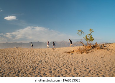 Death Valley, California, USA - April 14, 2021.  Group Of People Hiking In Desert. Mesquite Sand Dunes Vista Point In Death Valley National Park, California