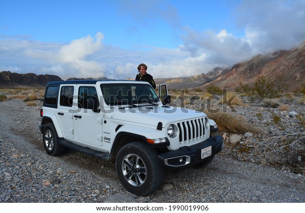 Death\
Valley, California, USA - December 24, 2019 - white Jeep Wrangler\
Sahara off road on the Hole in the Wall\
Road