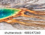 Deatiled photo of Grand Prismatic Spring from above with unrecognizable tourists watching it. Yellowstone National Park, Wyoming, USA