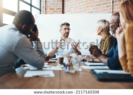 Debating before reaching a decision. Shot of a businessman leading a meeting in the boardroom.