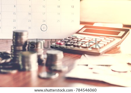  debt collection and tax season concept with deadline calendar remind note,coins,banks,calculator on table, background ,time to pay concept 