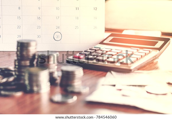  debt collection and tax season concept with\
deadline calendar remind note,coins,banks,calculator on table,\
background ,time to pay concept\
