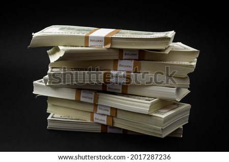 Debt payment, wealth transfer and economic activity concept with pile of money and hundred dollar bills bundle isolated on black background with clipping path cutout