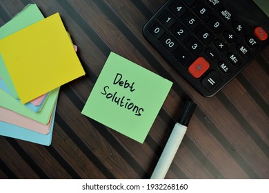 Debt Solution write on sticky notes isolated on Wooden Table.
