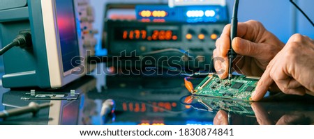 Debugging electronics device. PCB witch microcontroller in electronics laboratory