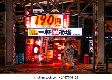 DEC 4, 2018 Tokyo, Japan - Izakaya Bar And Night Street Restaurant With Neon Signs And Local People Walking On Small Street Near Kanda JR Station