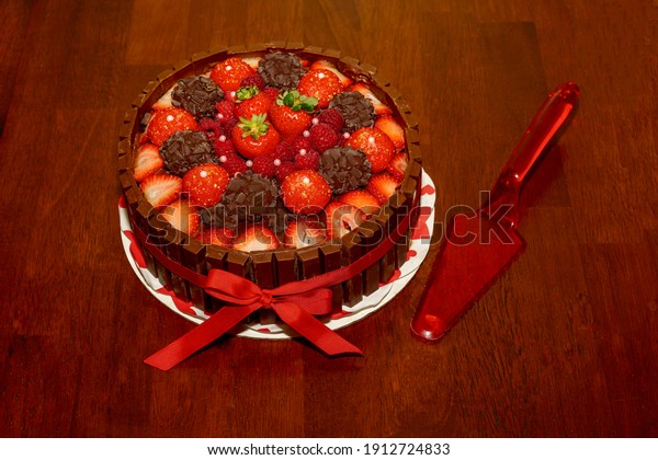 Decadent cake with chocolate truffles, candy and\
chocolate bars on wooden table\
