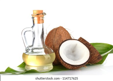 decanter with coconut oil and coconuts isolated on white
