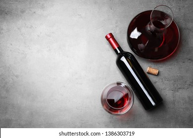 Decanter, glass and bottle with red wine on color background, flat lay. Space for text