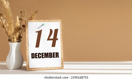 december 14. 14th day of month, calendar date.White vase with dead wood next to cork board with numbers. White-beige background with striped shadow. Concept of day of year, time planner, winter month.