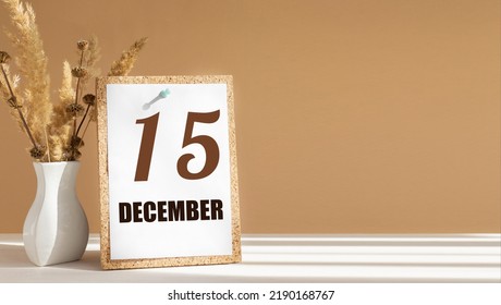 december 15. 15th day of month, calendar date.White vase with dead wood next to cork board with numbers. White-beige background with striped shadow. Concept of day of year, time planner, winter month.