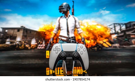 December 20, 2020, Odessa, Ukraine. White new Playstation 5 gamepad on the background of the game PUBG. Cybersport poster concept.