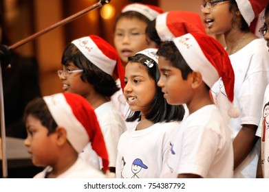 December 2016,Kuala Lumpur,Malaysia.Selective Focus On A Group Of Kids Choir Wearing Christmas  Santa Claus Hats At Christmas Dinner Party Event At A Christmas Celebration.