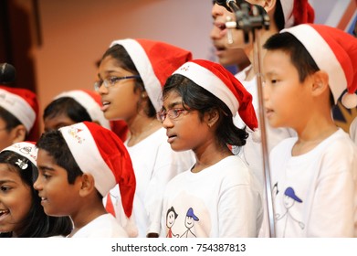 December 2016,Kuala Lumpur,Malaysia.Selective Focus On A Group Of Kids Choir Wearing Christmas  Santa Claus Hats At Christmas Dinner Party Event At A Christmas Celebration.