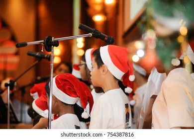 December 2016,Kuala Lumpur,Malaysia.Selective Focus On A Group Of Kids Choir Wearing Christmas  Santa Claus Hats At Christmas Dinner Party Event At A Christmas Celebration.