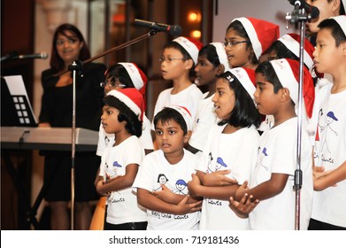 December 2016,Malaysia. A Group Of Kids Choir Wearing Christmas Santa Claus Hat At Christmas Dinner Event With Artificial Grain Effects.Christmas Celebration.