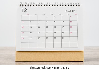 December 2021 Calendar desk for organizer to plan and reminder on wooden table.