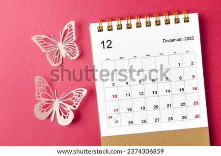December 2023 calendar desk for the organizer to plan and reminder with butterfly paer on red background.