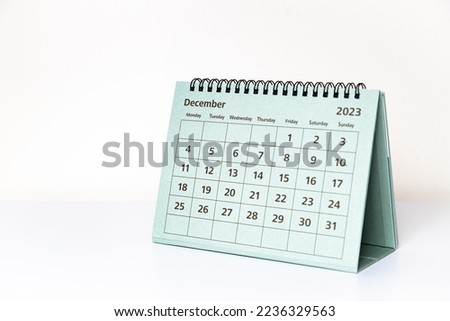 December 2023 deck calendar on white table. 