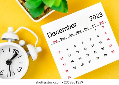 December 2023 Monthly calendar for 2023 year with alarm clock on yellow background. - Shutterstock ID 2358801359