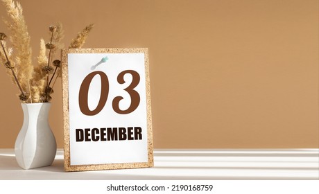 december 3. 3th day of month, calendar date.White vase with dead wood next to cork board with numbers. White-beige background with striped shadow. Concept of day of year, time planner, winter month.