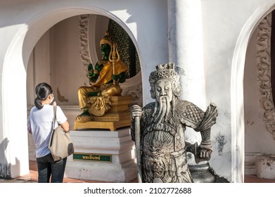 December 30 ,2021, A backside of Asia traveler prays to respect to Indra God statue with signboard in thai word " Phra In " at Phra Pathom Chedi the landmark of Nakorn Pathom province , Thailand