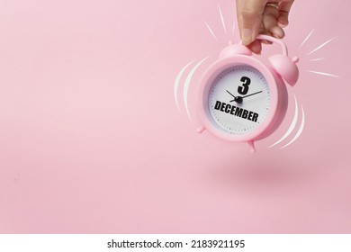 December 3rd. Day 3 of month, Calendar date. The morning alarm clock jumping up from the bell with calendar date on a pink background.  Winter month, day of the year concept