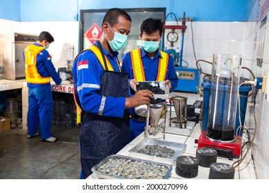 
December 6 2017.Uniformed asphalt company laboratory workers are testing the quality of the asphalt and gravel mixture to find the best formula.Purwakarta-Indonesia