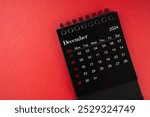 December black desk calendar for 2024 year on red cover background with copy space.