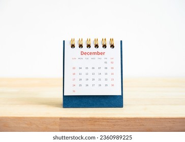 December page on 2023 desk calendar for the organizer and schedule plan isolated on wood table and white background. Front view of blue small table calendar with page of the 12th month. - Shutterstock ID 2360989225