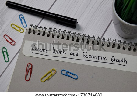 Decent Work and Economic Growth write on sticky notes isolated on office desk