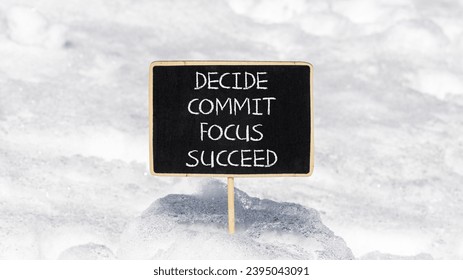 Decide commit focus succeed symbol. Concept word Decide Commit Focus Succeed on beautiful blackboard. Beautiful white snow background. Business decide commit focus succeed concept. Copy space. - Shutterstock ID 2395043091