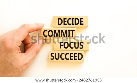 Decide commit focus succeed symbol. Concept word Decide Commit Focus Succeed on wooden block. Beautiful white background. Businessman hand. Business decide commit focus succeed concept. Copy space.