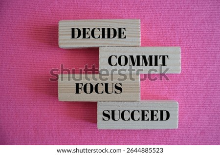 Decide commit focus succeed symbol. Decide commit focus succeed  written on wooden blocks. Background pink