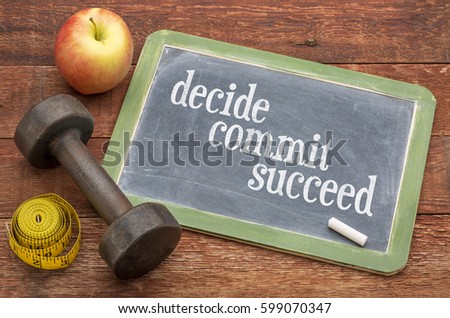 Decide, commit, succeed concept -  slate blackboard sign against weathered red painted barn wood with a dumbbell, apple and tape measure